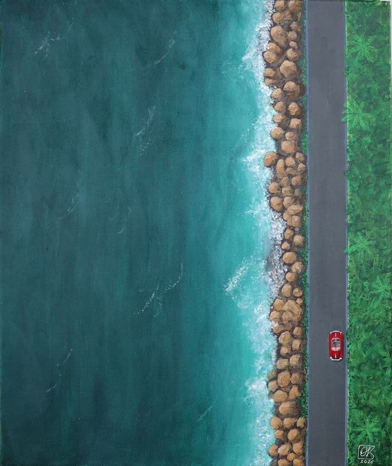 A bird's eye view of the coast, with a red Porsche on the road